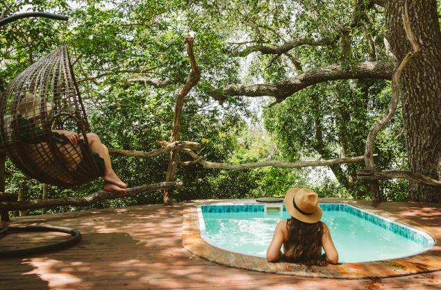 The pool at Rufiji River Camp is set under the shade of towering trees