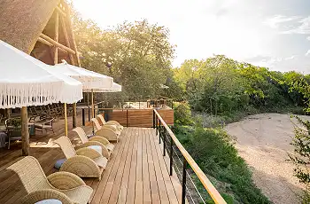 The deck overlooks a sandy river bed at Thornbush Game Lodge